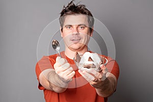 Young man holds a plate of chocolate ice cream.