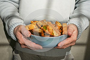 A young man holds a plate with homemade cookies with raisins, chocolate, nuts. Breakfast. Close.