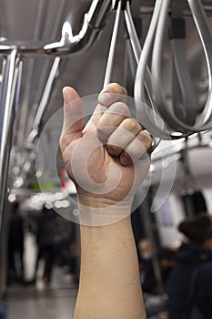 The young man holds the sling while traveling in the subway photo