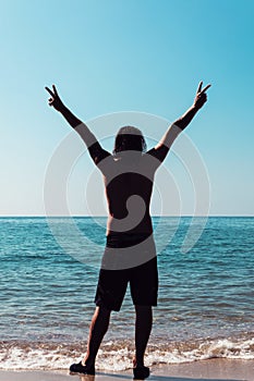 Young Man Holds Up Peace Sign, Towards Clouds