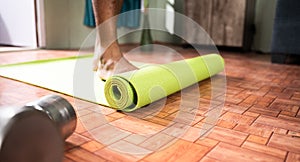 Young man at home arranging yoga mat before starting exercise - Concept of medical, helathcare, Fitness. photo
