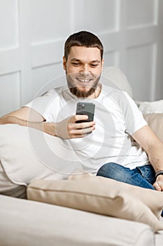 young man at home on the couch talking video call from the phone