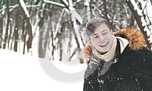 Young man in hood in the park in winter