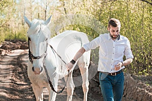 Young man with horse. Autumn outdoors scene