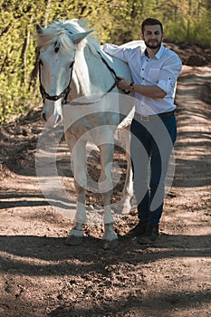 Young man with horse. Autumn outdoors scene