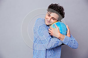 Young man hugging globe