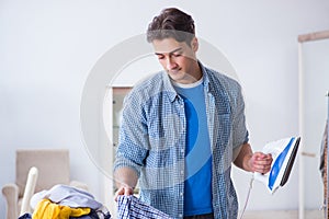 The young man husband doing clothing ironing at home