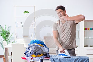 The young man husband doing clothing ironing at home