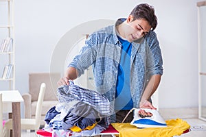 The young man husband doing clothing ironing at home