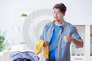 The young man husband doing clothing ironing at home