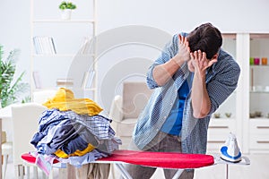 The young man husband doing clothing ironing at home