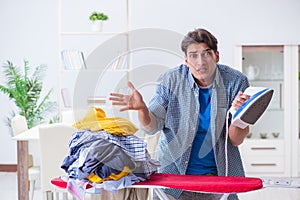 The young man husband doing clothing ironing at home