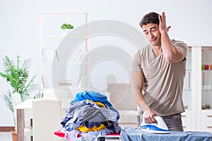 The young man husband doing clothing ironing at home