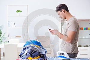 The young man husband doing clothing ironing at home