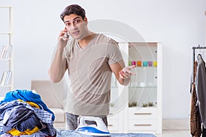 The young man husband doing clothing ironing at home