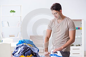 The young man husband doing clothing ironing at home