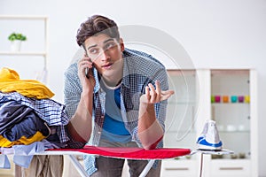 The young man husband doing clothing ironing at home