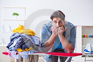 The young man husband doing clothing ironing at home