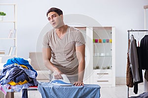 The young man husband doing clothing ironing at home