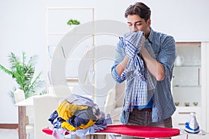 The young man husband doing clothing ironing at home