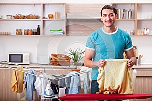 The young man husband doing clothing ironing at home