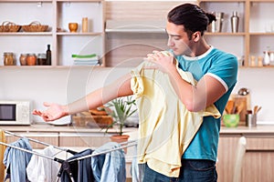 The young man husband doing clothing ironing at home