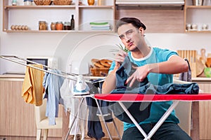 The young man husband doing clothing ironing at home