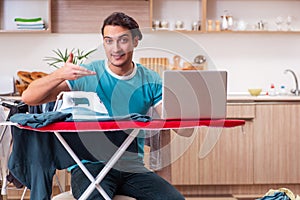 The young man husband doing clothing ironing at home