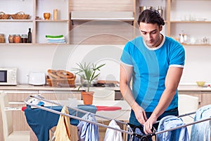 The young man husband doing clothing ironing at home