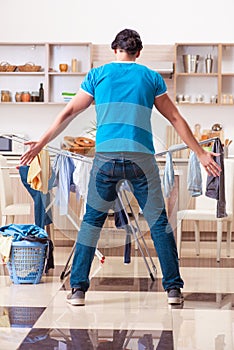 The young man husband doing clothing ironing at home