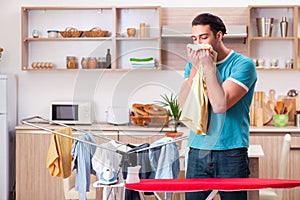 The young man husband doing clothing ironing at home