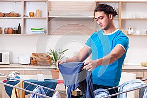 The young man husband doing clothing ironing at home