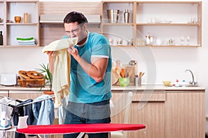 The young man husband doing clothing ironing at home