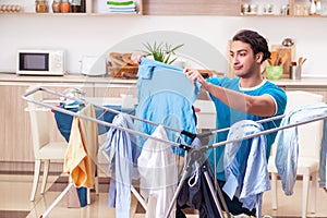 Young man husband doing clothing ironing at home