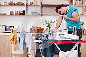 Young man husband doing clothing ironing at home