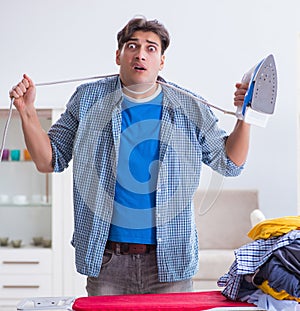 Young man husband doing clothing ironing at home