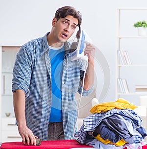 The young man husband doing clothing ironing at home