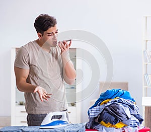 Young man husband doing clothing ironing at home