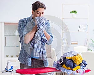 Young man husband doing clothing ironing at home