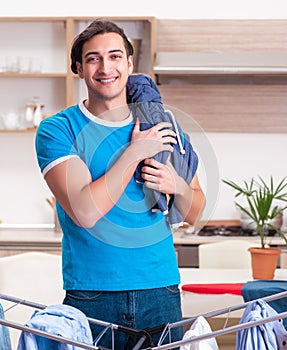 Young man husband doing clothing ironing at home