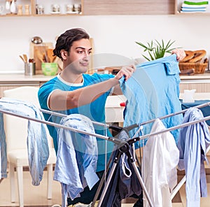 Young man husband doing clothing ironing at home