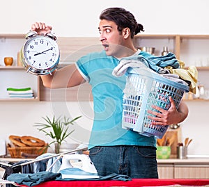 Young man husband doing clothing ironing at home