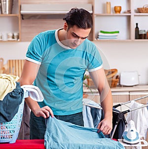 Young man husband doing clothing ironing at home