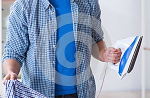 Young man husband doing clothing ironing at home