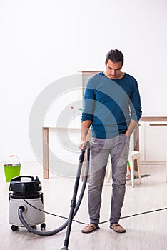 Young man husband doing housework at home