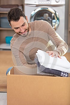 young man husband doing laundry at home