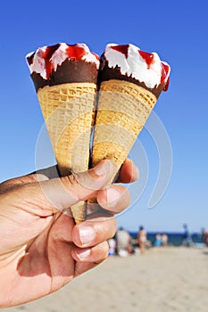 Young man with ice cream cones on the beach
