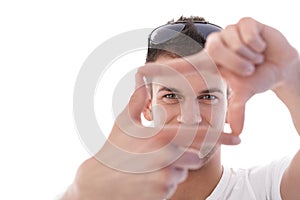 Young man imitating photographing smiling