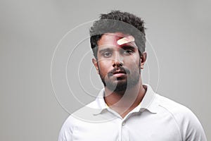 A young man of Indian origin with a bruised forehead