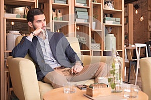 Young man indoors sitting interior coffee bar